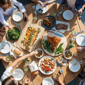 people eating on table with foods