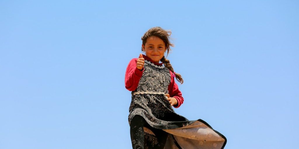 A little girl that is standing on a skateboard