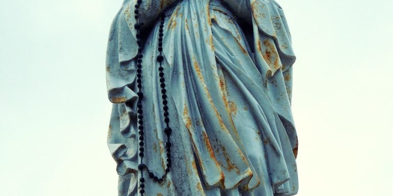 a statue of a woman holding her hands to her face