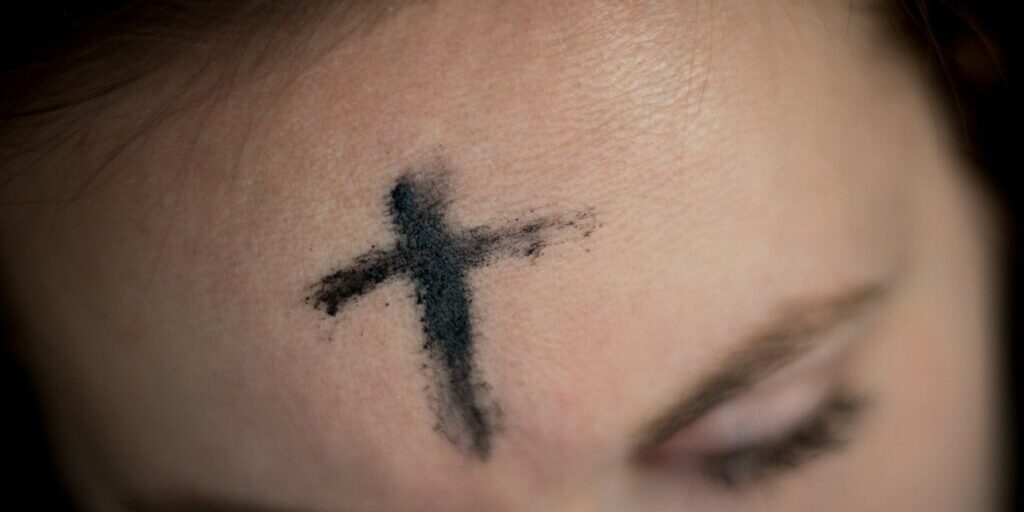 black cross on person's forehead